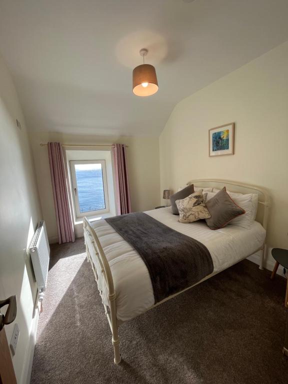 a bedroom with a large bed with a window at Old Irish farmhouse in Dingle