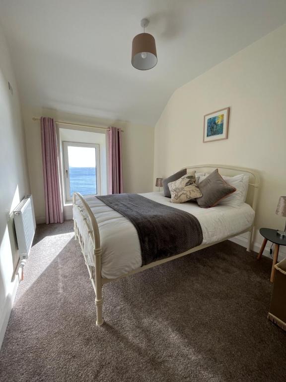 a bedroom with a large bed with a window at Old Irish farmhouse in Dingle