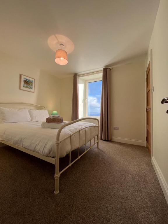 a bedroom with a large bed with a window at Old Irish farmhouse in Dingle