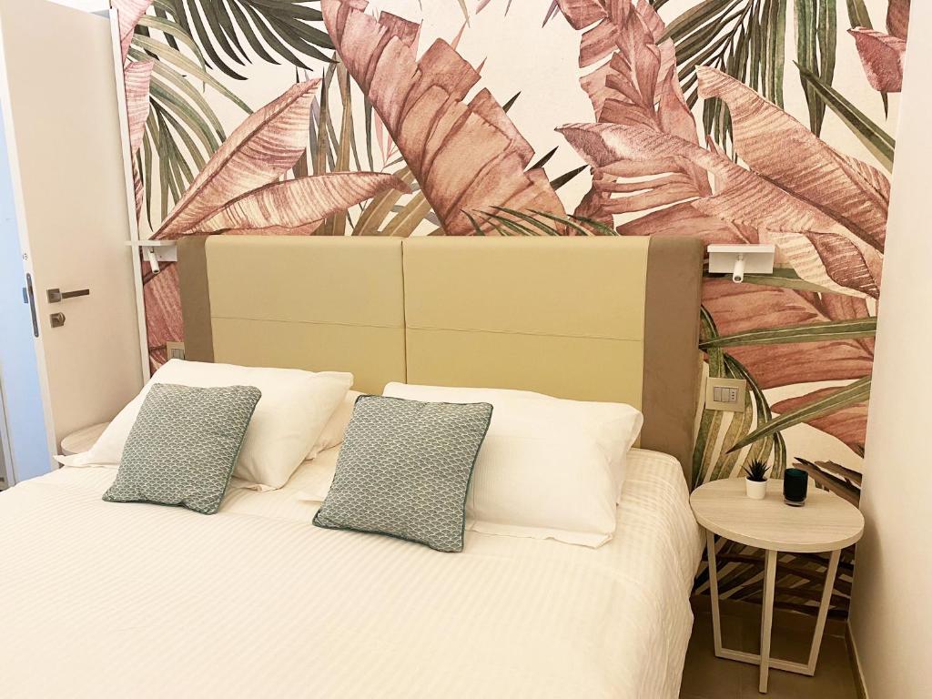 1 dormitorio con 1 cama con un mural tropical en la pared en Naturamare B&B, en Villapiana