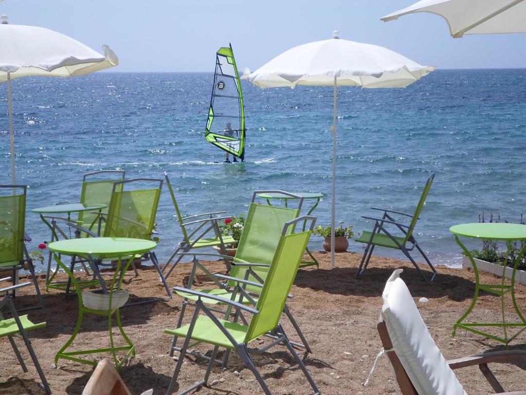 - un groupe de chaises et de tables sur la plage dans l'établissement Kassimiotis, à Áyios Andréas Messinias