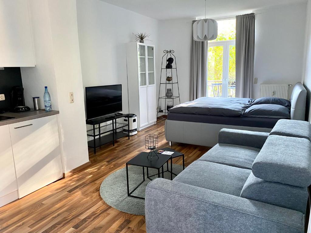 uma sala de estar com um sofá e uma cama em Zentrale Ferienwohnung mit Balkon in Aachen em Aachen