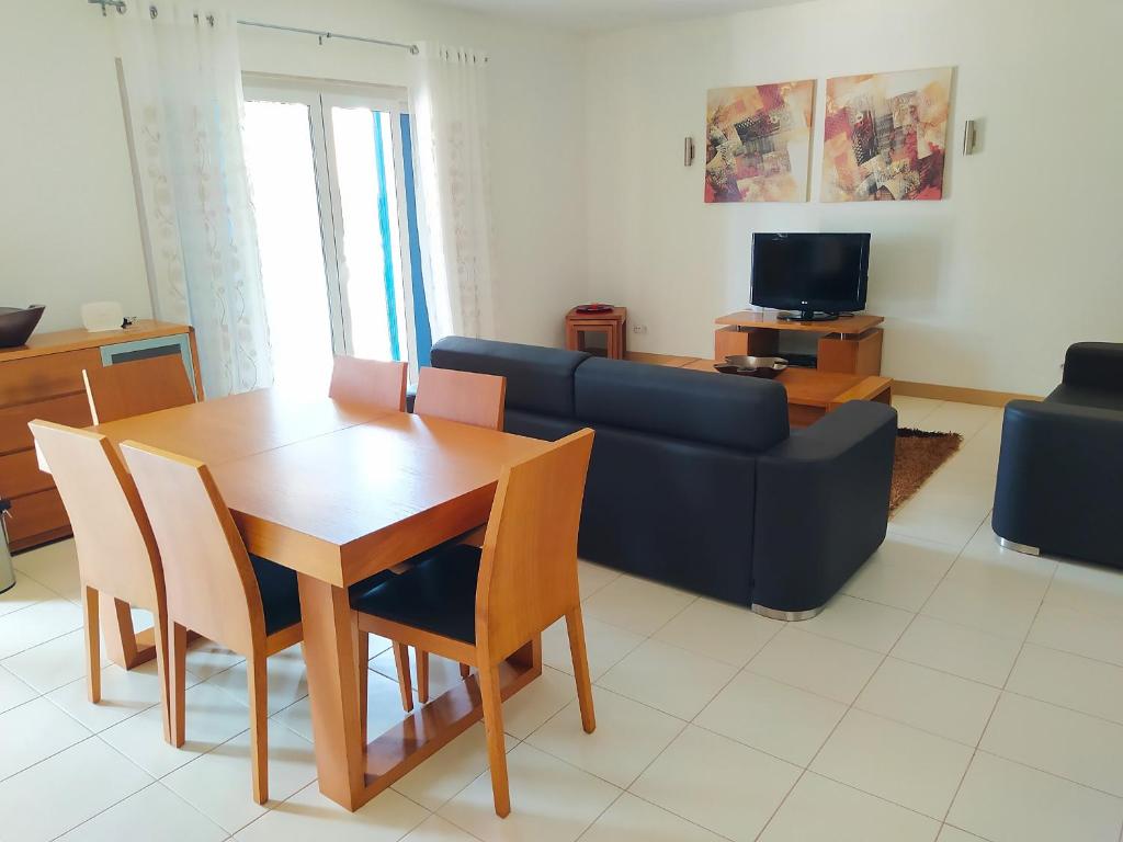 sala de estar con mesa y sofá azul en AH - Vila Verde Private Apartment, en Santa Maria