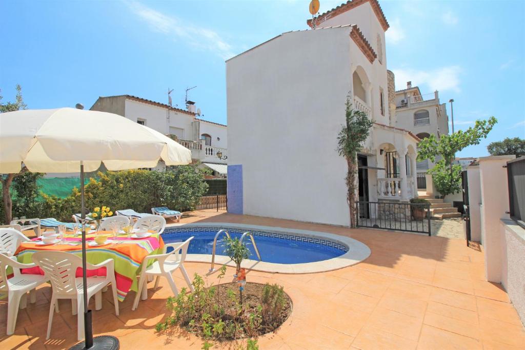 a patio with a table and chairs and a pool at Apart-rent Casa con piscina Sant Maurici 0191 in Empuriabrava
