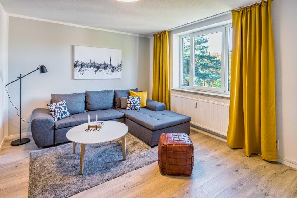 een woonkamer met een blauwe bank en een tafel bij new apartment I cozy I Netflix I WLAN I near airport in Dresden