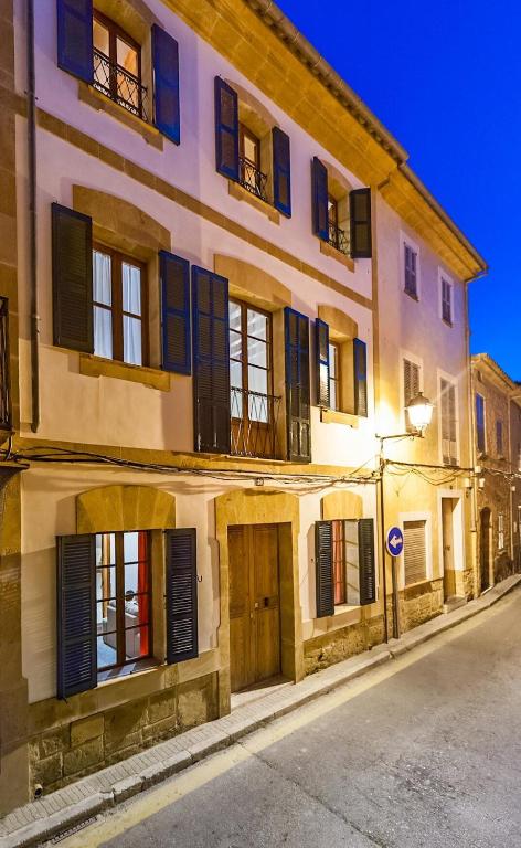 a large building with blue shutters on a street at Holiday Home Ca Na Blan ca in Alcudia