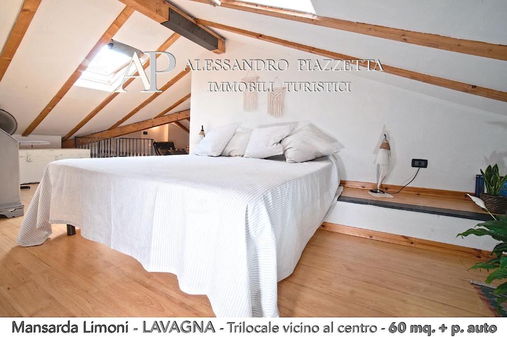 1 dormitorio con 1 cama blanca grande en una habitación en Mansarda Limoni, en Lavagna