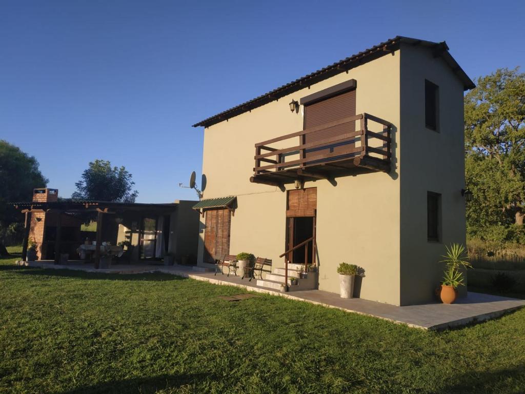 une maison avec un balcon et une cour dans l'établissement Paraíso Serrano, à Villa Serrana