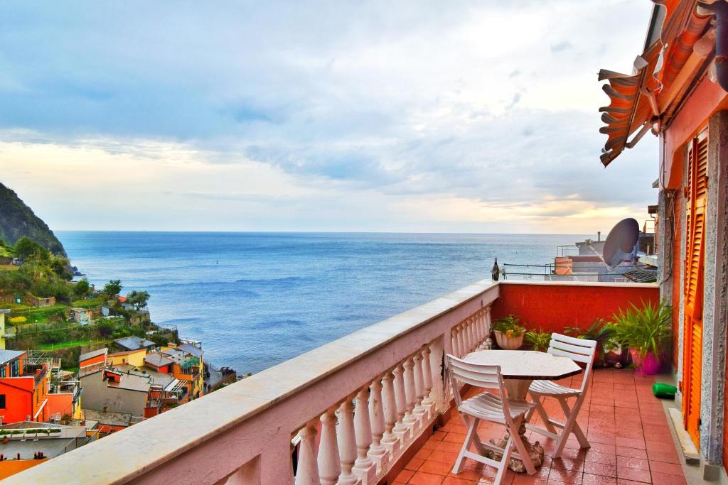 balkon ze stołem i krzesłami oraz widokiem na ocean w obiekcie Giadera penthouse 5terreparco w mieście Riomaggiore