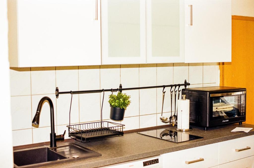 a kitchen counter with a sink and a microwave at Vivo Hospital Maxi in Herne