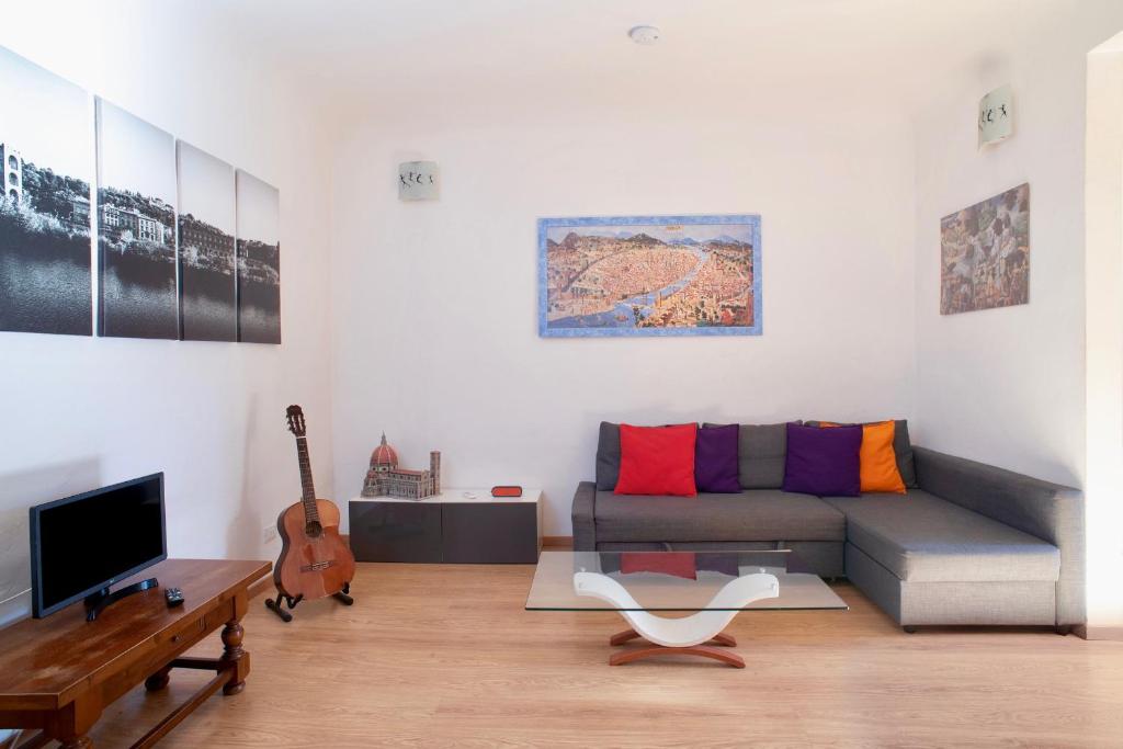sala de estar con sofá y guitarra en Apartment Palazzuolo, en Florencia