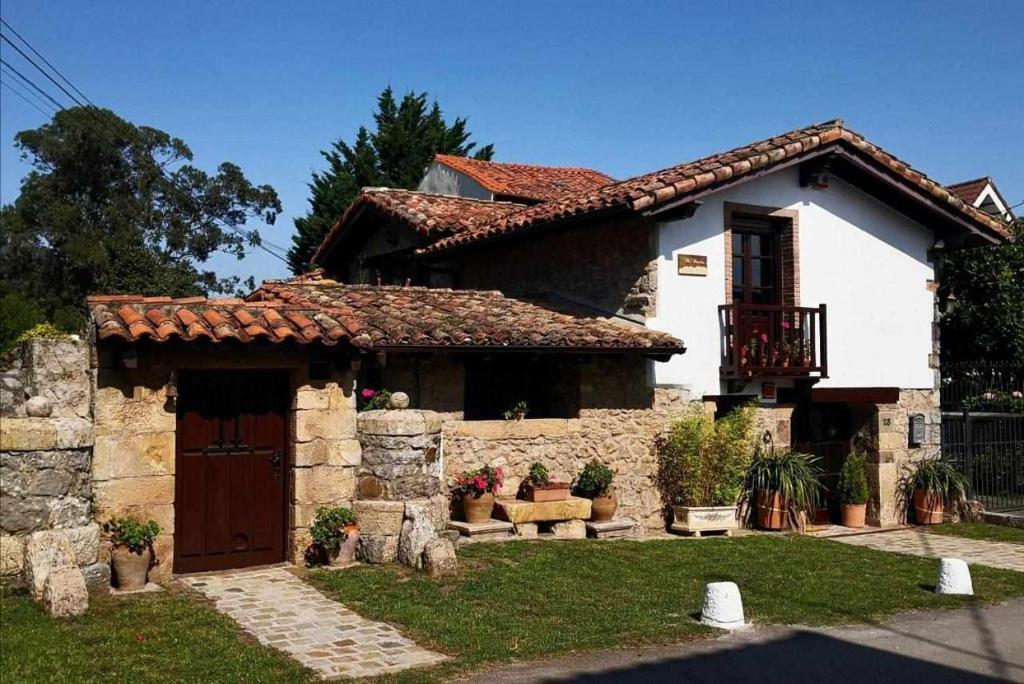 a white house with a door and a yard at Villa Moreneta in Sobremazas
