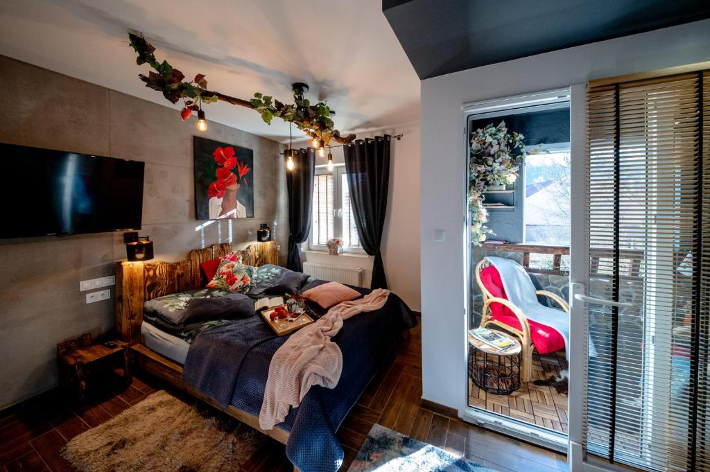 - une chambre avec un lit et une télévision à écran plat dans l'établissement Apartamenty Stara Mleczarnia, à Ustrzyki Dolne