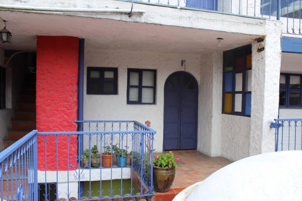 a house with a blue door and a balcony at Suite in beautiful Historical Guapulo, Quito in Quito