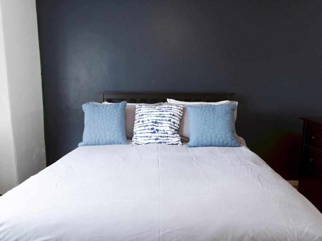 un letto con cuscini bianchi e blu di Pass the Keys Cozy two bed flat near Glasgow Airport & Paisley a Paisley