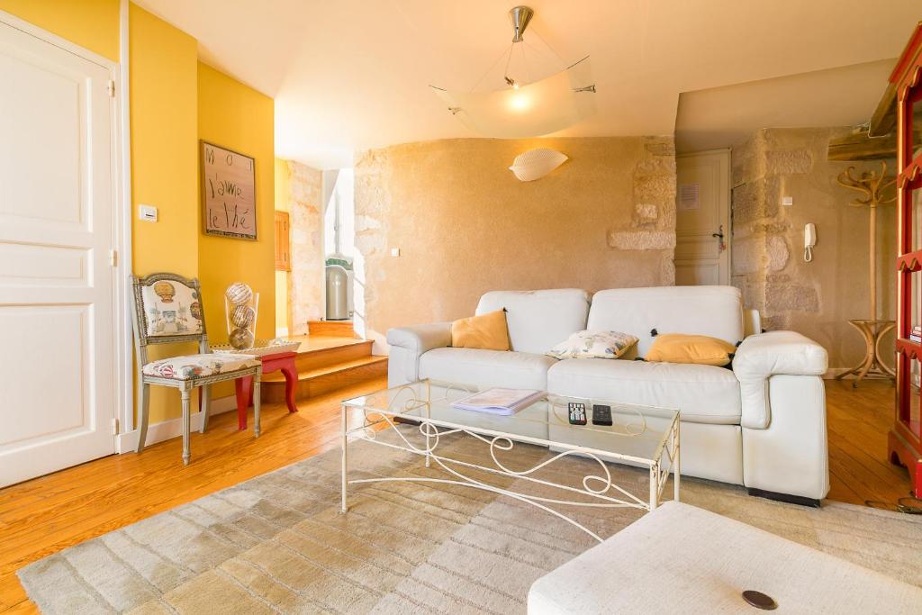 uma sala de estar com um sofá branco e uma mesa em Le panoramique, au centre historique de Dijon em Dijon