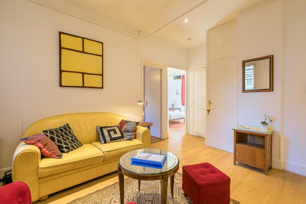 a living room with a yellow couch and a table at Le Chaussier, en plein centre ville de Dijon in Dijon