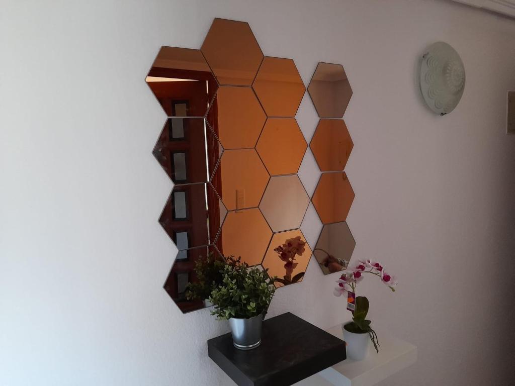 ein Spiegel an der Wand mit einem Tisch und Blumen in der Unterkunft Torresmar home in Segorbe