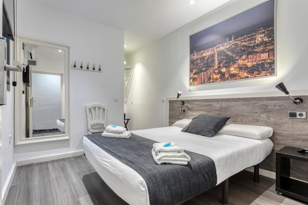 um quarto com uma cama grande e toalhas em HOSTAL BEDMATES em Barcelona