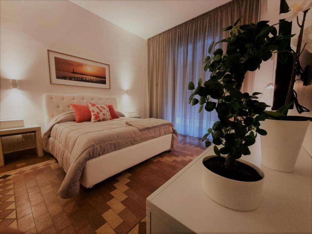 a bedroom with a bed and a potted plant at GRAFEA Apartment Catania in Catania