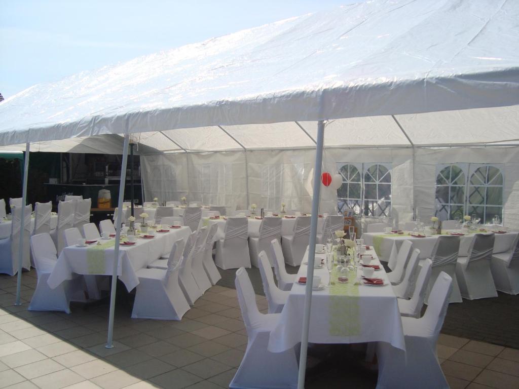 a white tent with white tables and white chairs at Hotel Gasthof Goldener Hahn in Frankfurt Oder