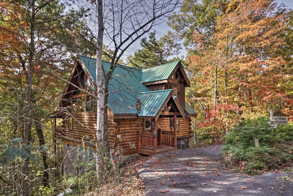 une cabane en rondins dans les bois avec un toit vert dans l'établissement Smoky Mountain Log Cabin 7 Mi to Gatlinburg!, à Sevierville