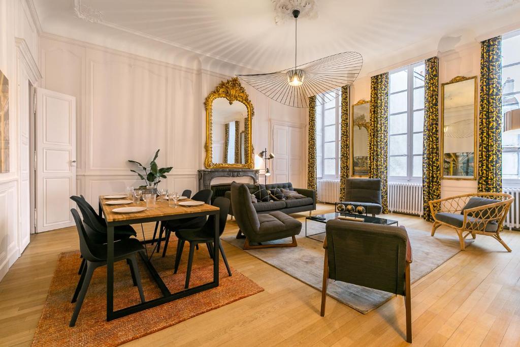 a living room with a table and chairs at L'historique au cœur de ville in Dijon