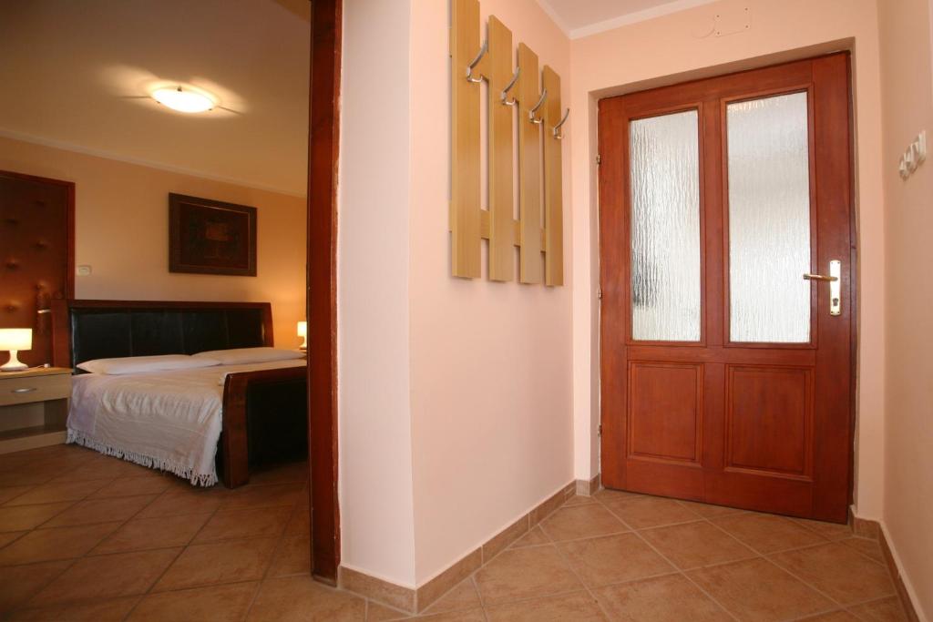 a bedroom with a bed and a door to a room at Apartments Neda - Poreč South in Poreč