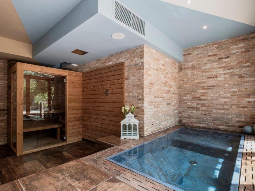 a hot tub in a room with a brick wall at Accademia al Colle in Bologna