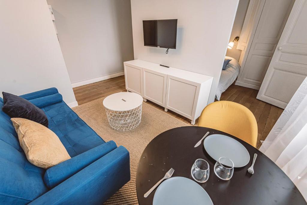 un salon avec un canapé bleu et une table dans l'établissement Roi soleil, face à la Cathédrale - 2G, à Reims