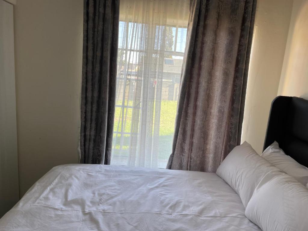 uma cama em frente a uma janela com em House 210 holiday rentals em Alberton