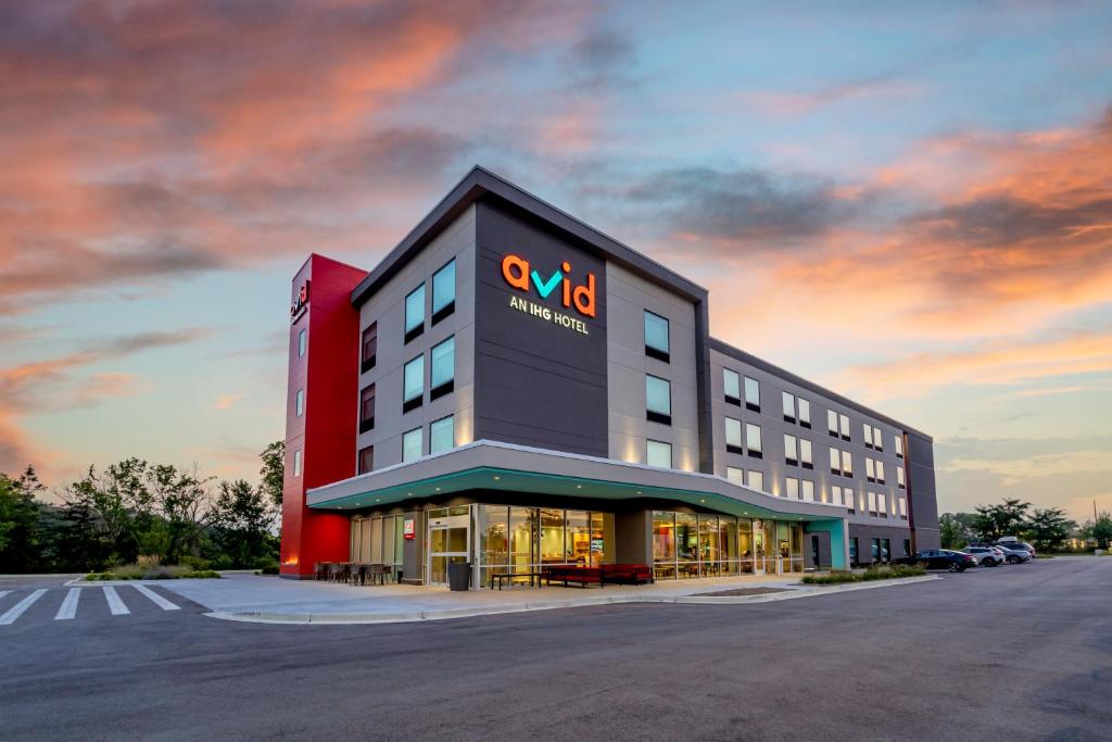 a building with a sign on the side of it at avid hotels Milwaukee West - Waukesha, an IHG Hotel in Pewaukee