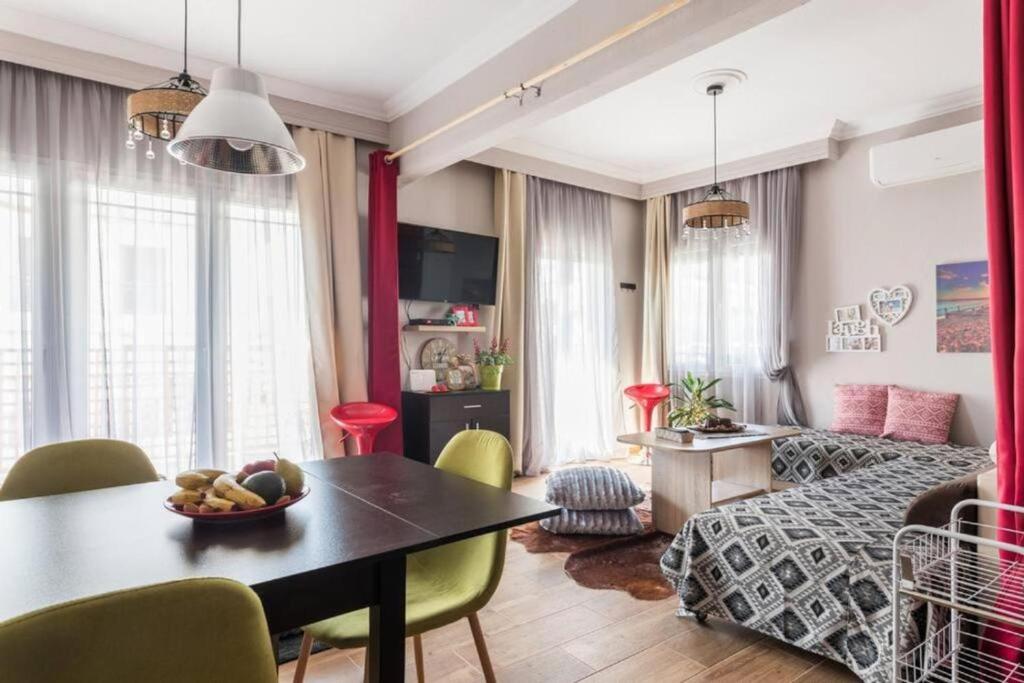 ein Wohnzimmer mit einem Tisch und ein Wohnzimmer mit einem Bett in der Unterkunft Flat on Walkstreet freeparking in Thessaloniki