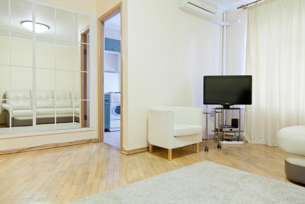 a living room with a television and a chair at KvartiraSvobodna - Apartment at Bolshoy Kondratyevskiy in Moscow