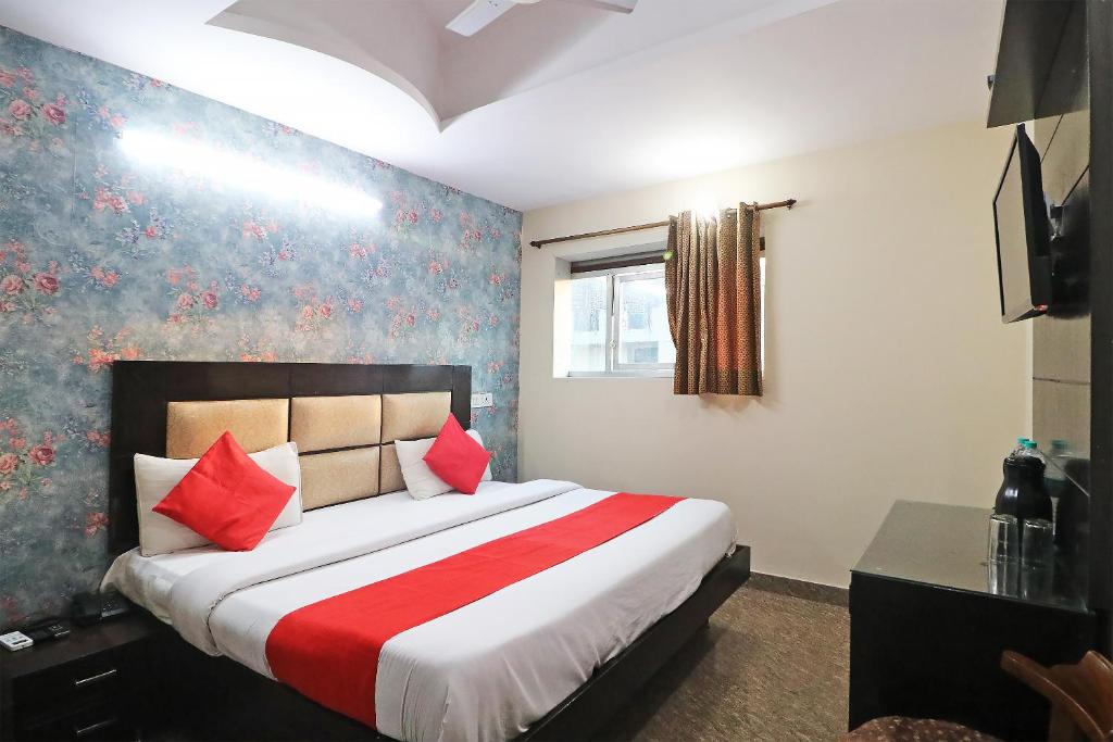 sypialnia z dużym łóżkiem z czerwonymi poduszkami w obiekcie Hotel Westend Holiday Home 5 mint from Nizamuddin Railway Station w Nowym Delhi