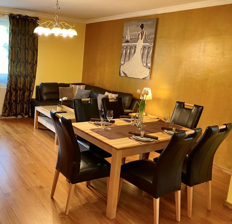 a dining room with a wooden table and black chairs at Apartment Ani in Ramsau am Dachstein