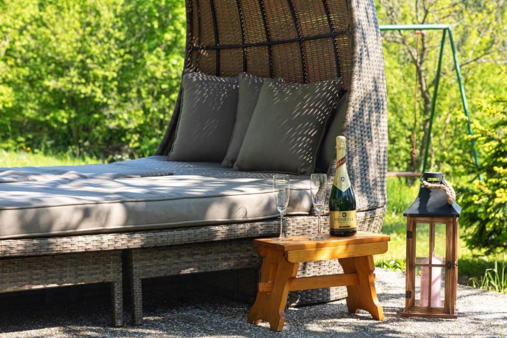 Zalesina的住宿－FoRest Chalet，一张床铺和一张桌子上的一瓶葡萄酒