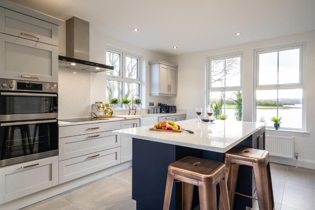 a kitchen with a large island with two stools at Escape Ordinary at Lily's Pad in Enniskillen