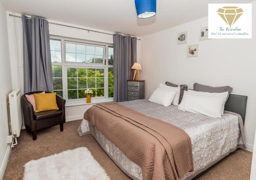1 dormitorio con 1 cama, 1 silla y 1 ventana en 2 Bed Apartment-5 Guests - Business-Relocation-Parking - The Brighton Short Stay & serviced Apartments, en Brighton & Hove