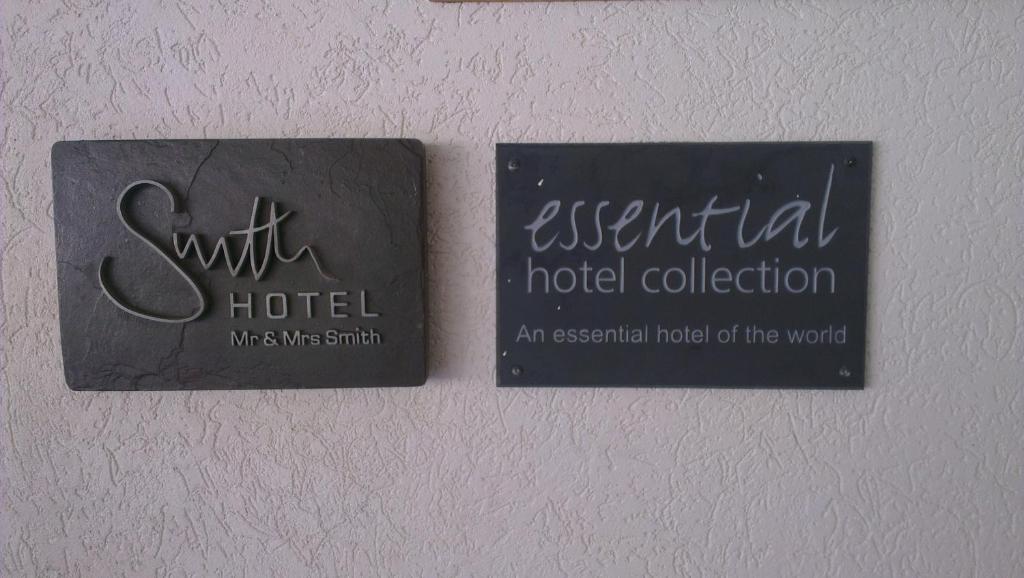 two signs on a wall with an essential hotel collection at The Atlantis Historic Inn in Saint Joseph
