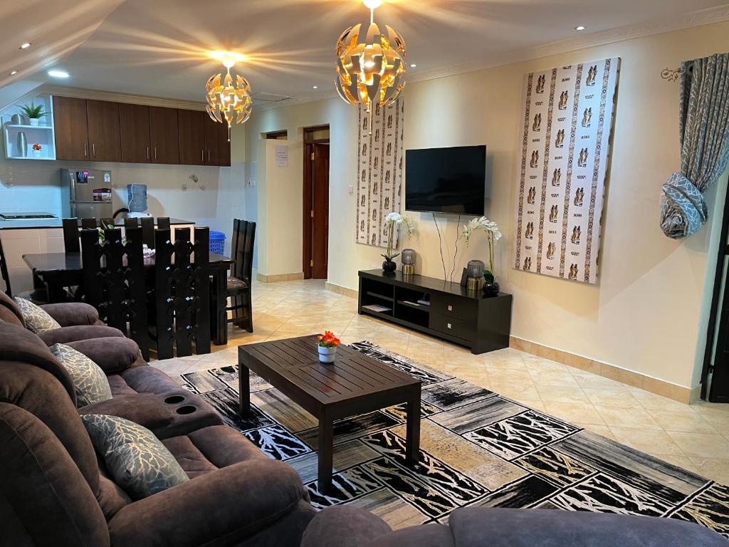 ein Wohnzimmer mit einem Sofa und einem Tisch in der Unterkunft Tsavo House-A cosy home 15 min from the JKIA Airport and SGR Terminus in Syokimau