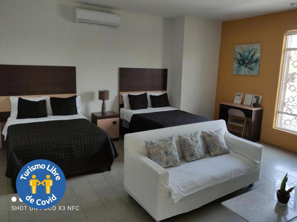 Habitación de hotel con 2 camas y sofá en Hotel del Bosque en Torreón