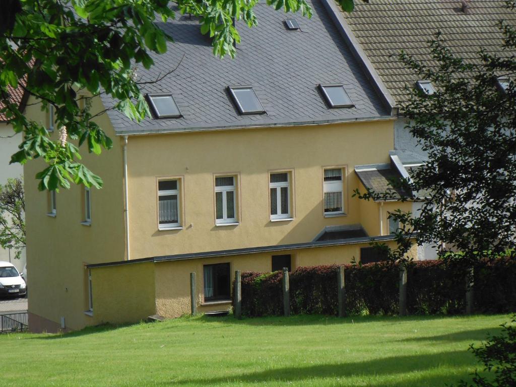 una casa amarilla con techo gris en Ferienwohnung Eppendorf, en Eppendorf