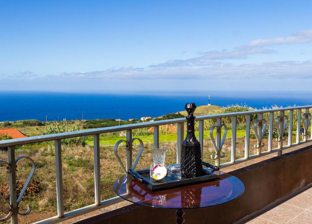 una mesa en un balcón con vistas al océano en Casa do Prendinha by Horizon View Madeira, en Ponta do Pargo