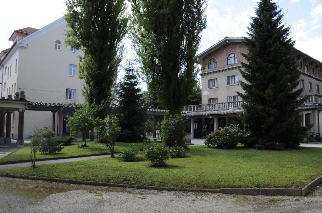 a large white building with trees in front of it at Hostel Tabor in Ljubljana