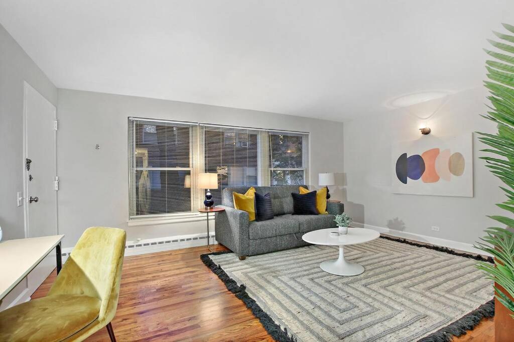 een woonkamer met een bank en een tafel bij Charming 1BR Apt with Spacious Living Room - Foster 1S in Chicago