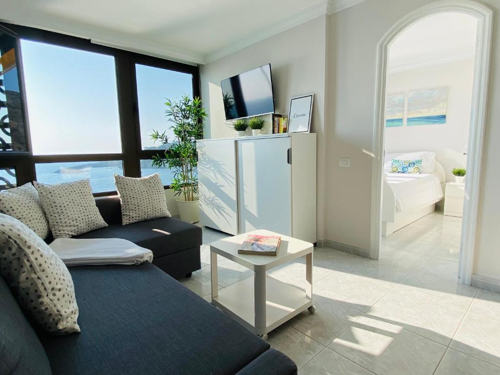 a living room with a couch and a table at Doñana12 by SunHousesCanarias in Patalavaca