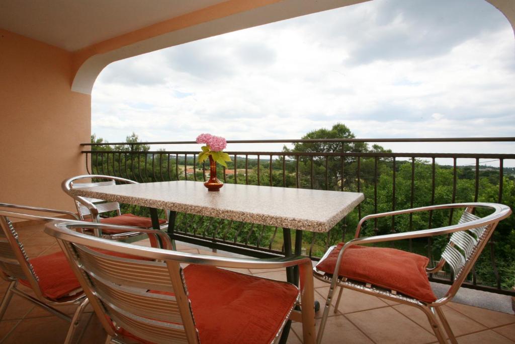 a table and chairs on a balcony with a view at Apartments Neda - Poreč South in Poreč