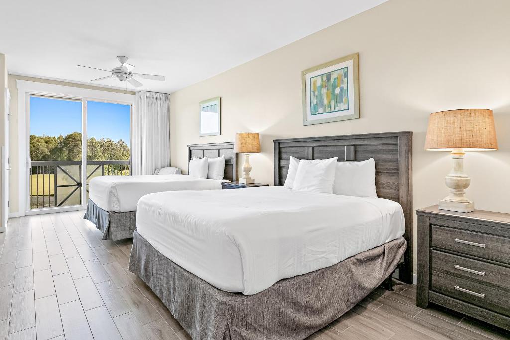 a bedroom with two beds and a balcony at Elation #5216 in Destin