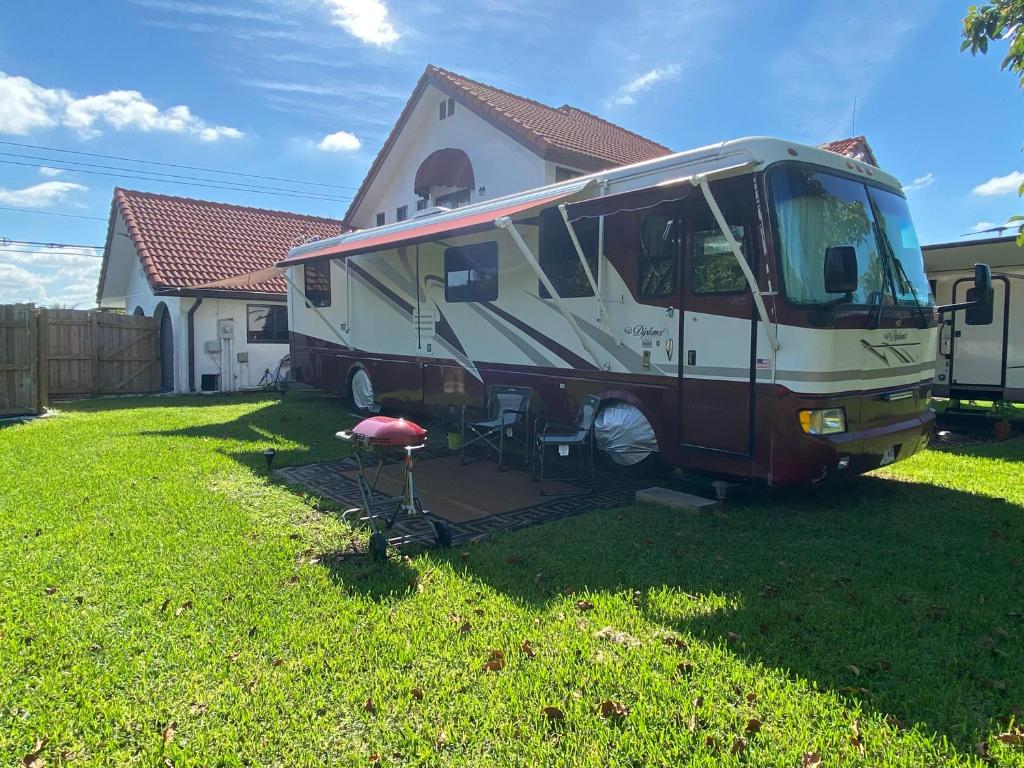 een camper geparkeerd in een tuin naast een huis bij Caravana RV in Miami